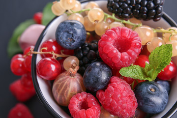 Cup with different ripe berries, closeup