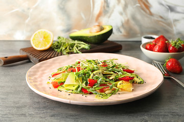 Plate with delicious fresh salad on table