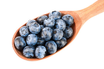 fresh ripe blueberry with leaf in wooden spoon isolated on white background. Top view. Flat lay pattern
