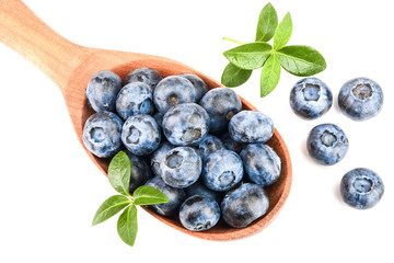 fresh ripe blueberry with leaf in wooden spoon isolated on white background. Top view. Flat lay pattern