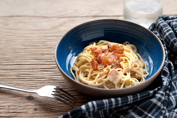 Tradition Italian food pasta carbonara, Spaghetti with bacon, ham and parmesan cheese on wooden table.