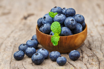 Blueberries in a wood bowl on a wooden table, Healthy eating and nutrition concept