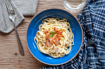 Tradition Italian food pasta carbonara, Spaghetti with bacon, ham and parmesan cheese on wooden table.