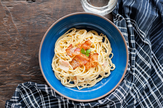 Tradition Italian food pasta carbonara, Spaghetti with bacon, ham and parmesan cheese on wooden table.