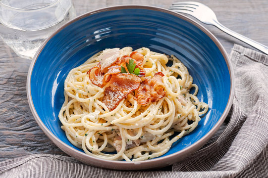 Tradition Italian food pasta carbonara, Spaghetti with bacon, ham and parmesan cheese on wooden table.