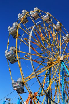 Colorful ferris wheel with bright blue sky background