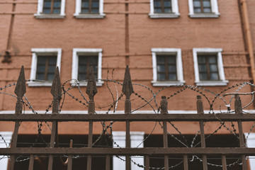 rusty fence with barbed wire on background jail