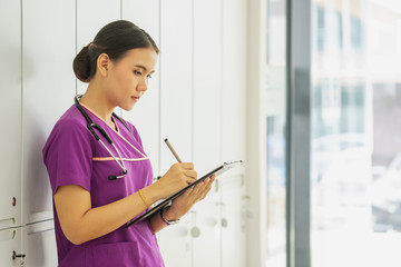 female doctor hold clipboard pad and fill medical history list at workplace.	