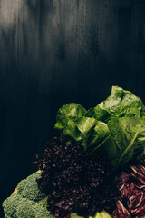 top view of broccoli and green salad on grey dark table