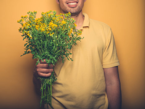 Young man holding bunch of horseweed