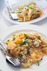 Oyster Omelette with Chili Sauce on white dish in local restaurant in Bangkok.
