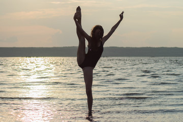 Fototapeta na wymiar beautiful girl doing gymnastics, yoga, dancing against the background of sunrise, sunset