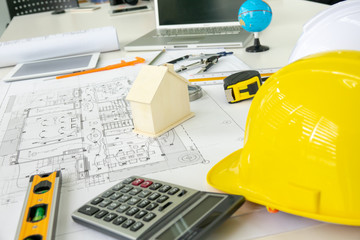 Architecture Desk with equipment architects On the desk with blueprint plan, helmet, wooden house...