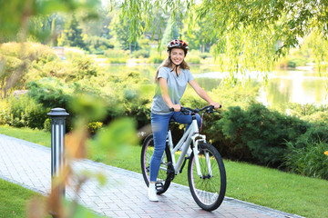 Young woman riding bicycle in park