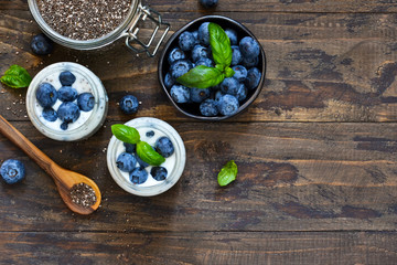 Homemade yogurt with sesena chia and blueberries that have a dark background. Proper nutrition.