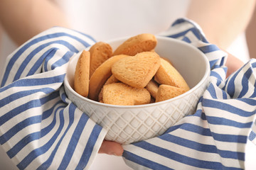 Woman holding bowl with tasty cookies, closeup