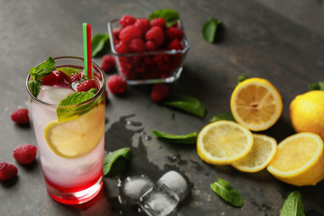 Glass of fresh raspberry mojito on table
