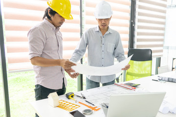 Two engineering men consalting on architect blueprint at office room. Selective focus.