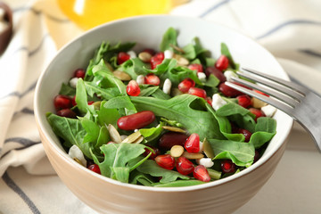 Bowl with delicious healthy fresh salad on table