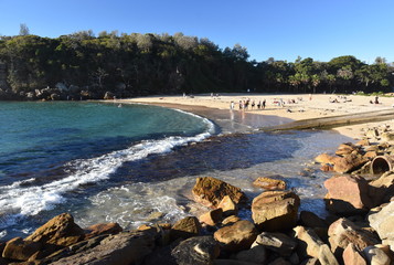 Shelly Beach and Cabbage Tree Bay Aquatic Reserve at Manly with sand and Tasman Sea. People relaxing on sandy Shelly beach at Manly.