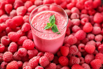 Glass with tasty smoothie and raspberries
