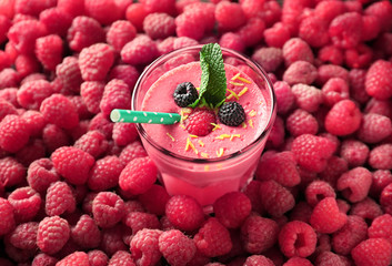 Glass with tasty smoothie and raspberries