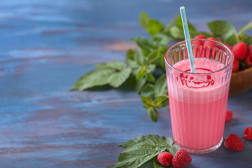 Glass with tasty raspberry smoothie on wooden table