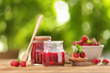 Composition with sweet raspberry jam on table outdoors