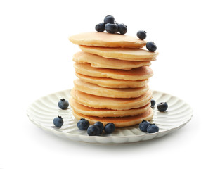 Plate with delicious pancakes and berries on white background