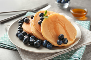 Plate with delicious pancakes and berries on light table, closeup
