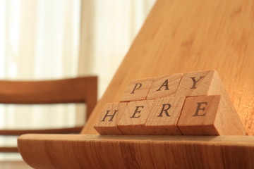 Wooden Block Text of Pay Here