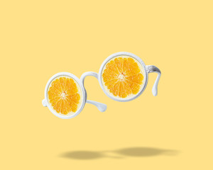 White sunglasses with orange on bright background. Summer minimal concept.