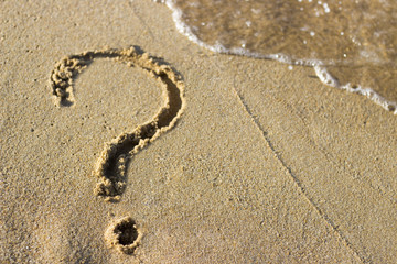 Fototapeta na wymiar question mark sign in sand beach