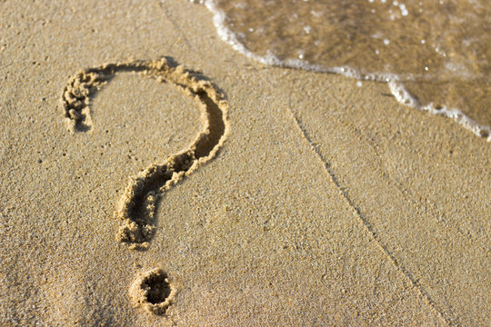 question mark sign in sand beach
