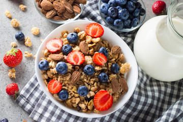 Healthy breakfast concept with oat flakes and fresh berries on rustic background. Food made of granola, muesli. Healthy banana smoothie with blackberries, muslie, strawberries, blueberries and honey.