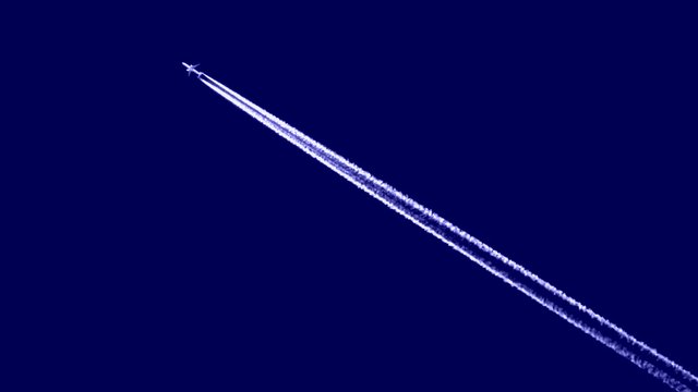 The plane flies on a blue background. Rapidly flying supersonic military fighter in the blue sky.