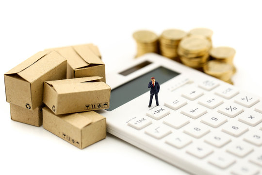 Miniature people : Businessman and box with  coins  and Calculator of tax,shipping, rent container, business concept.