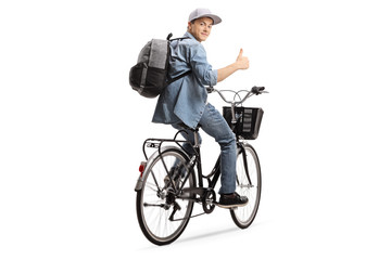 Fototapeta premium Teenager riding a bicycle and holding his thumb up