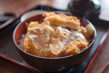 katsudon, Japanese food, a bowl of rice topped with a deep-fried pork cutlet, in the black bowl