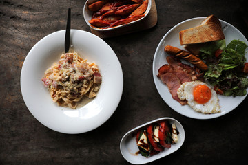 food flat lay top view with pasta and english breakfast on wood background