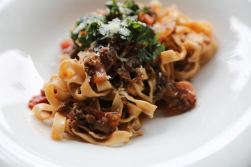 Pasta Fettuccine Bolognese with beef and tomato sauce on wood background in dark tone mystic light style
