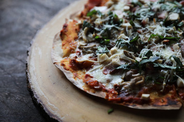 Pizza with  ham tomatoes mozzarella cheese and basil. Delicious italian pizza on wooden pizza board