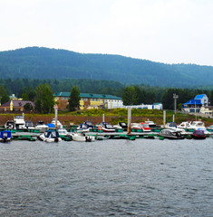 Fototapeta premium White yacht. Sailboat. Boat goes by sea. Motor ship.Pier. Port. Island in the sea. Mountains. Rocky shore. Beach. Sea blue water. Waves. Sea. Ripples on the water surface. Seascape. Rocky. The sea ag