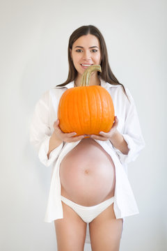 Pregnant Woman With Large Pumpkin. Healthy Concept