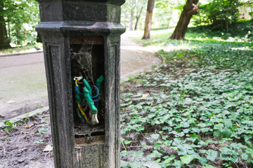 old electric cables in terrible condition in the lamp pillar in the park