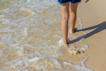 leg lady walk on the beach and ocean wave crash it