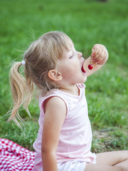 Young girl eating cherry outdoor