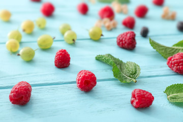 Fresh ripe berries on color wooden background