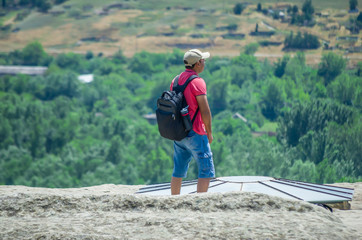 Naklejka premium Tourists enjoy the sunny weather and walk around the ancient rock city in Uplistsikhe (Upliscyche), Georgia
