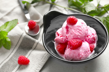 Bowl with delicious raspberry ice-cream on table